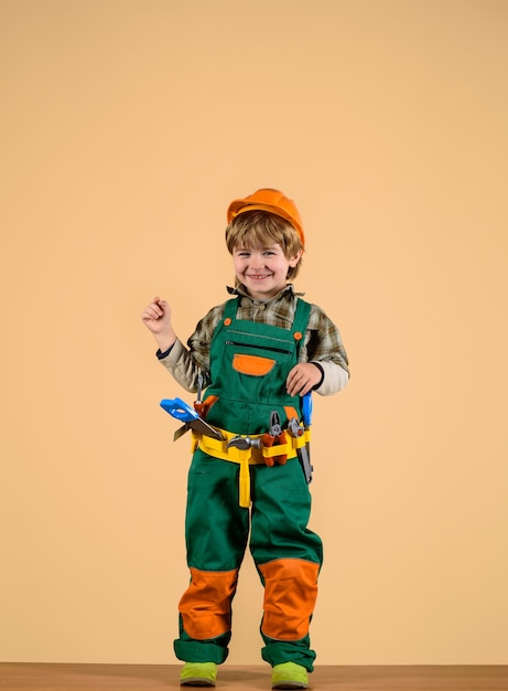 Niño constructor jugando con herramientas de reparación niño como trabajador de la construcción concepto de reparación niño en casco