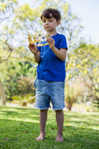 Foto niño con una corona en el parque