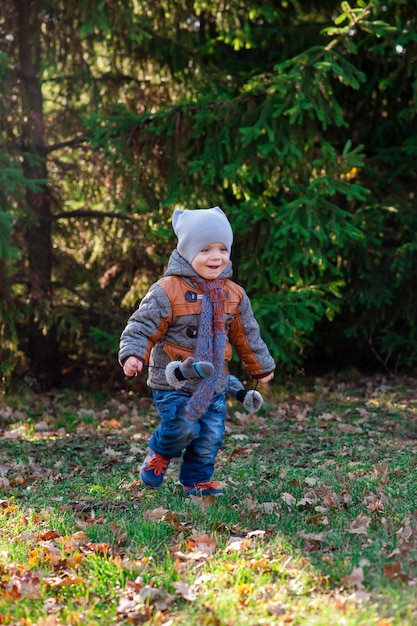 El niño corre al parque otoño.