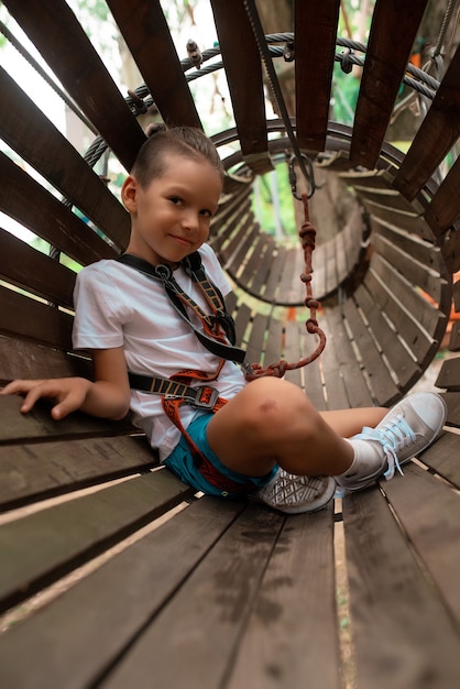 Niño corre una carrera de obstáculos en un parque de cuerdas