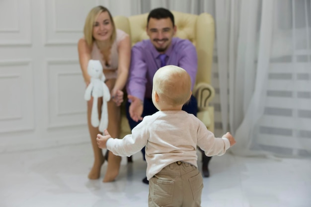 El niño corre hacia la madre y el padre que tira de las manos.