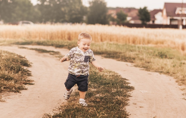 Foto niño corriendo por un camino rural en verano