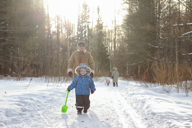 Niño corriendo en un parque de invierno y divertirse con la familia