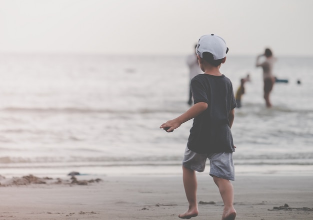 Niño corriendo a una playa de arena