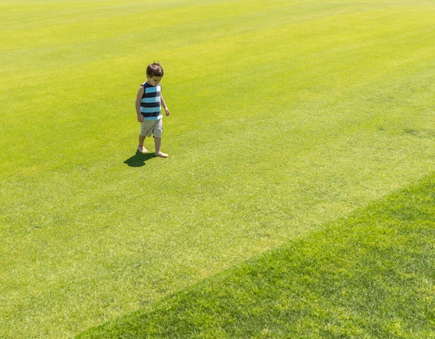 Foto niño corriendo en el prado verde