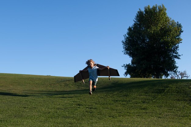 Niño corriendo sobre la hierba en el parque Infancia imaginación niño sueño de viajes de aventura Viajes y vacaciones con niños Niños libertad y despreocupación