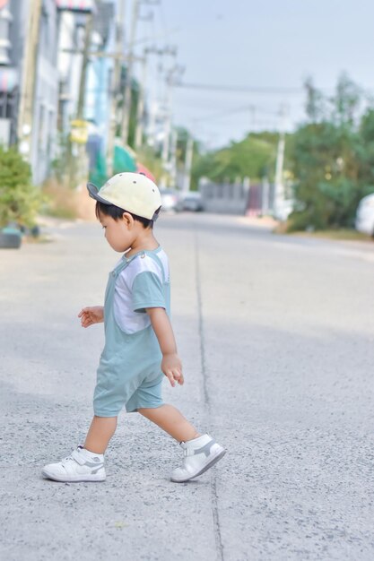 Un niño cruzando la calle con sombrero.