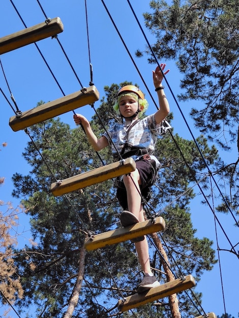 Niño cruzando un puente de madera en un patio de recreo