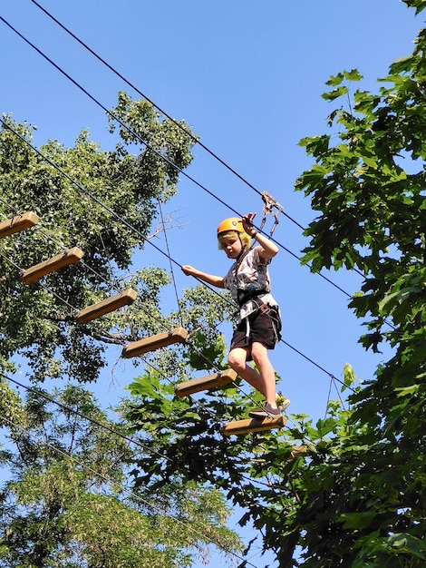 Niño cruzando un puente de madera en un patio de recreo