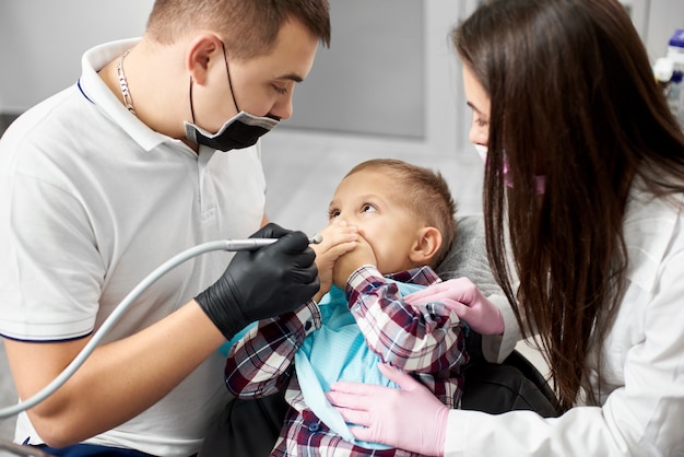 niño cubriéndose la boca mientras se realiza el tratamiento