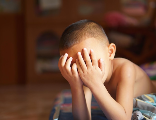 El niño se cubrió los ojos con las manos para bloquear el sol.