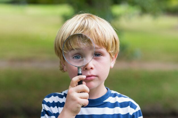 Niño curioso mirando a través de la lupa