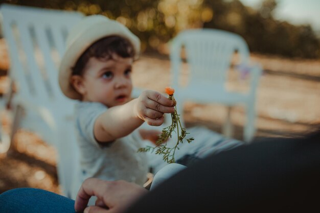 Niño dando verduras de raíz a una persona