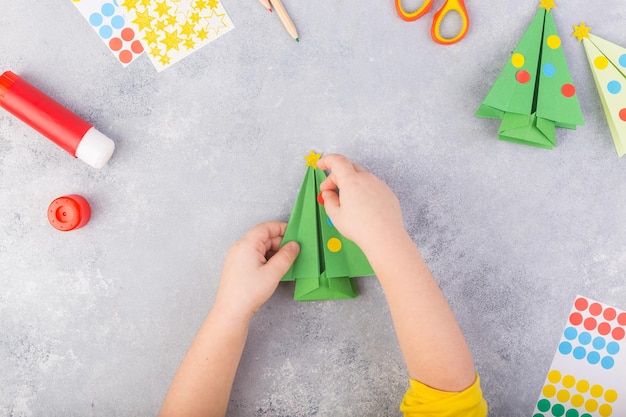 El niño decora el árbol de papel origami collage de papel de navidad hecho con sus propias manos arte infantil ...