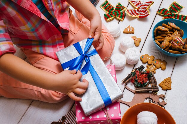 Niño decorando regalos en preparación navideña