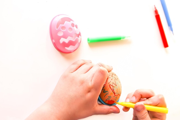 Niño decorar huevos de Pascua con marcadores de colores y plantillas de plástico