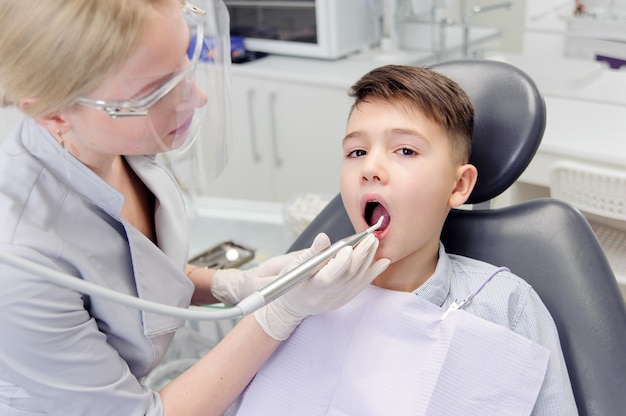 Un niño con un dentista en un consultorio dental.