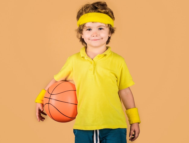 Niño deportivo. Niño sonriente con pelota de baloncesto. Actividades para niños. Pequeño jugador de baloncesto. Equipo de deporte.