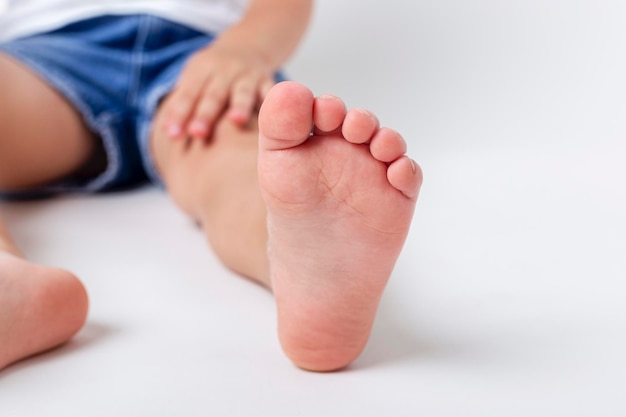 Niño descalzo. Foto de estudio sobre un fondo claro.