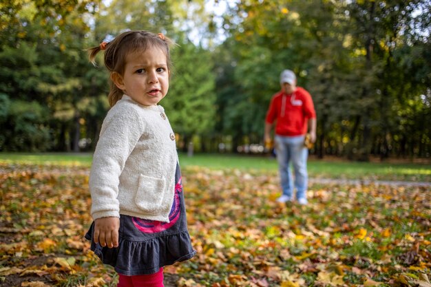 Niño descontento en el parque con papá niña enojada en el parque mira a la cámara padre y