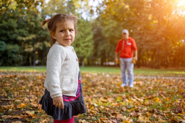 Niño descontento en el parque con papá niña enojada en el parque mira a la cámara padre y