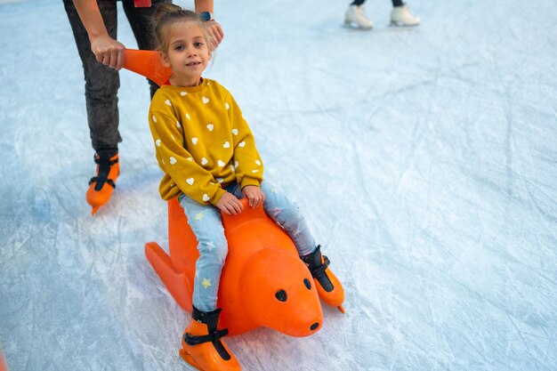 Un niño se desliza por la pista de hielo en un juguete