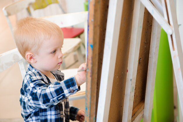 Un niño dibuja pinturas en una clase de arte