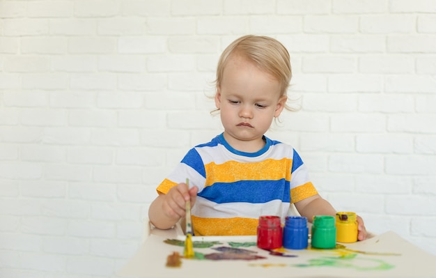 niño dibuja con pinturas, jugando en casa. niño juega en casa.