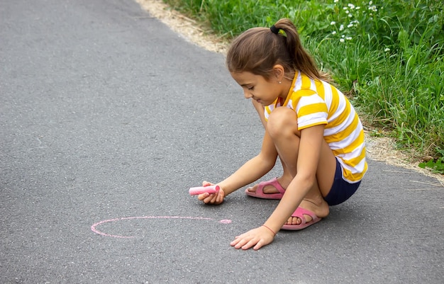 El niño dibuja con tiza en el pavimento el corazón es el sol Naturaleza