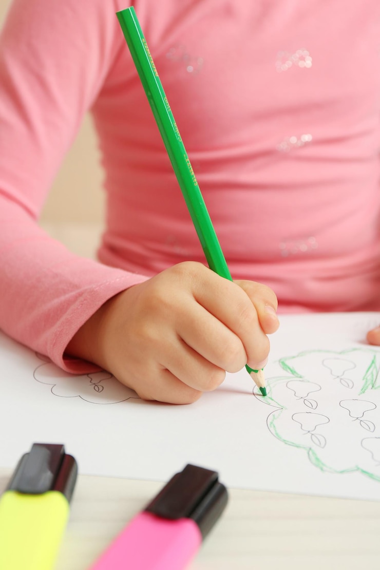 Foto niño dibujando un árbol con lápices en un primer plano de papel