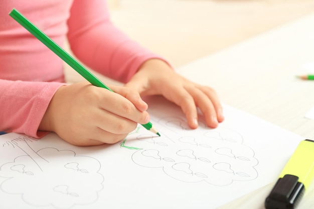 Niño dibujando un árbol con lápices en un primer plano de papel