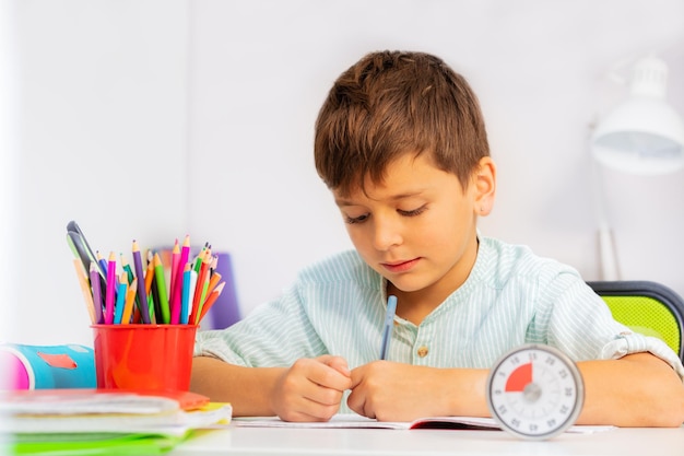 Foto niño dibujando en un libro en casa