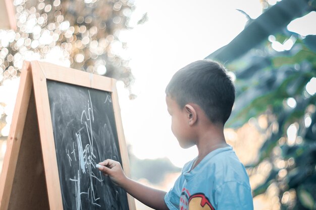 Niño dibujando en una pizarra. Aprendiendo en casa.