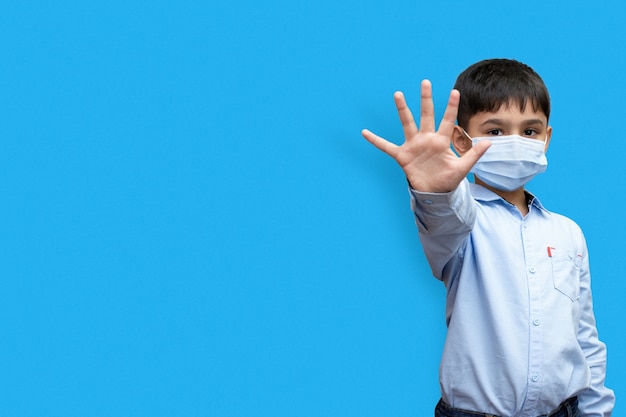 Foto niño diciendo stop con su mano aislado en un espacio de copia de fondo liso