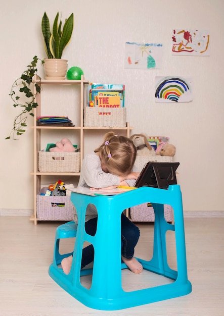 Niño con dificultades de aprendizaje Niña preescolar cansada haciendo la tarea