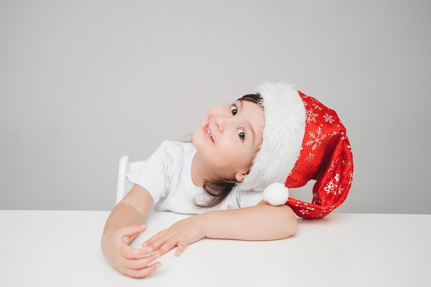 Un niño con un disfraz de año nuevo está esperando las vacaciones con una sonrisa alegre de una niña en el año nuevo ...