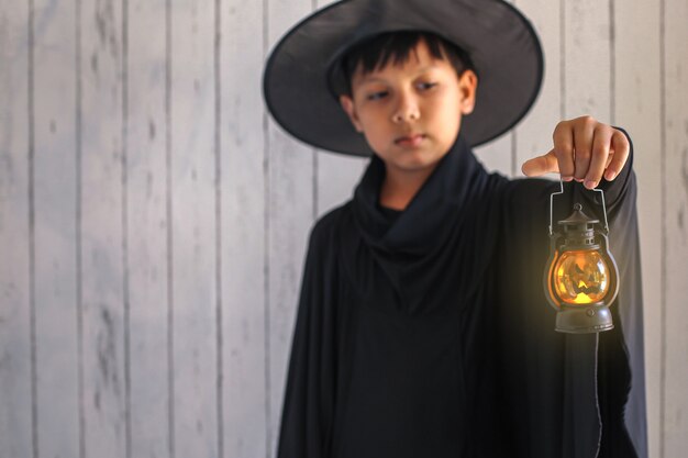Un niño con disfraz de halloween y sosteniendo una linterna.