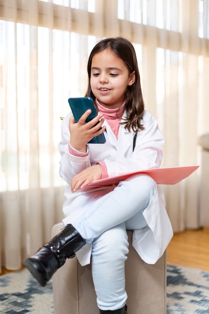 Niño disfrazado de médico usando un teléfono móvil