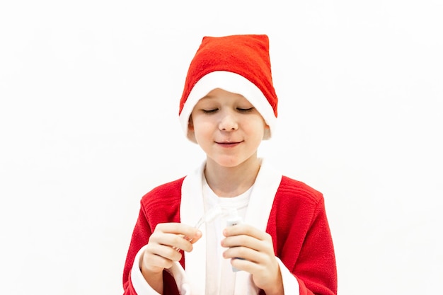 Un niño disfrazado de Santa se cepilla los dientes en el baño.