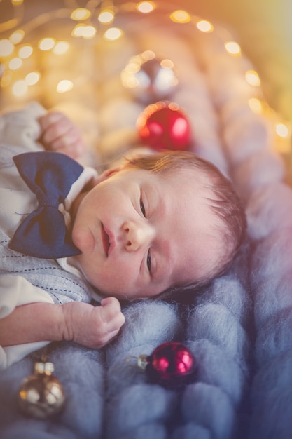 Niño disfrazado tumbado con decoración navideña.