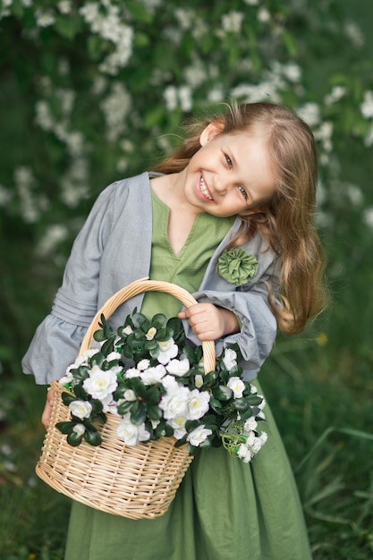 El niño disfruta de la primavera y una canasta de flores en sus manos 1823