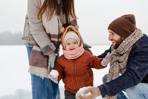 Foto niño disfrutando de actividades de invierno con su familia.