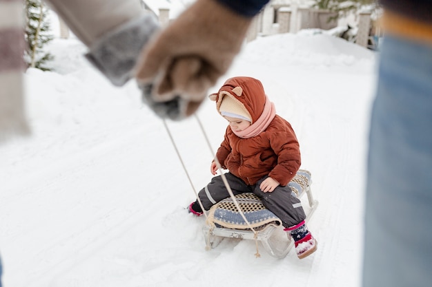 Foto niño disfrutando de actividades de invierno con su familia.