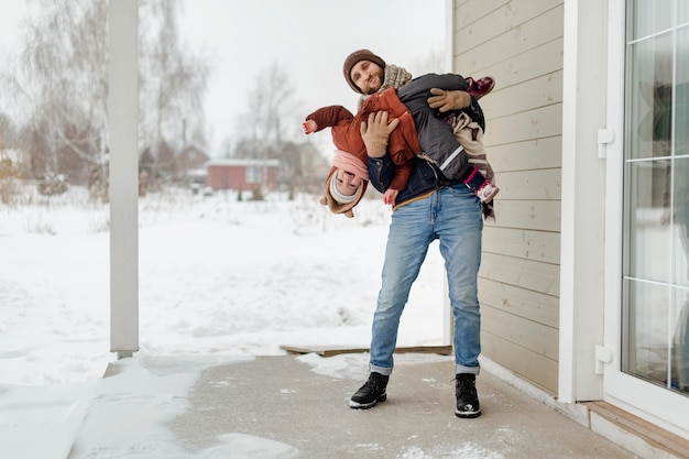 Foto niño disfrutando de actividades de invierno con su familia.