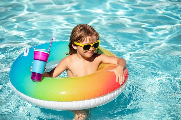 Niño divertido bebe cóctel en la piscina Niño en el parque acuático Vacaciones de verano