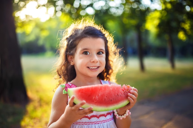 Foto niño divertido comiendo sandía al aire libre en el parque de verano centrado en los ojos comida saludable para niños estilo de vida juvenil