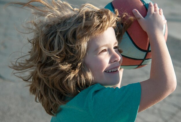 Niño divertido emocionado jugando baloncesto primer plano retrato de niño niño divertido cara deportiva lindo niño sonriente