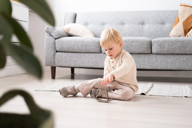 Niño divertido jugando con un caballo de juguete de madera en una sala de estar moderna