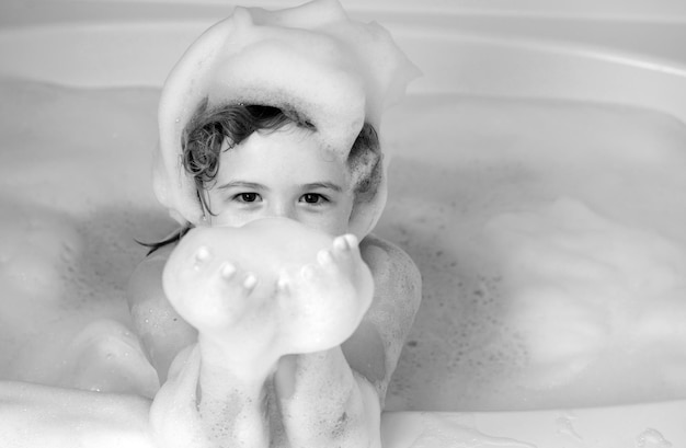 Niño divertido jugando con espuma en el baño