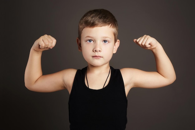 Foto niño divertido mostrando sus músculos